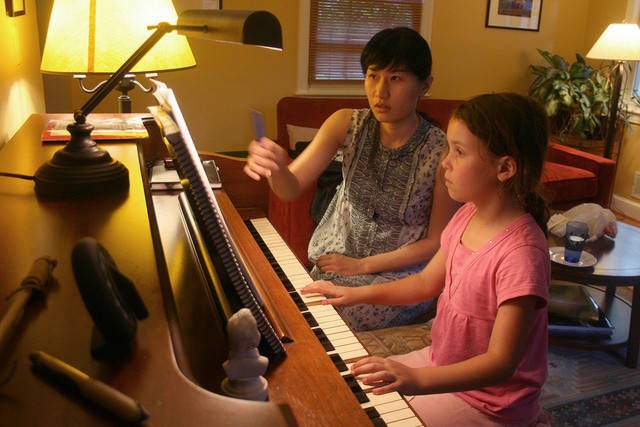 Girl with piano tutor