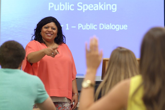 Woman in pink shirt teaching a Public Speaking class
