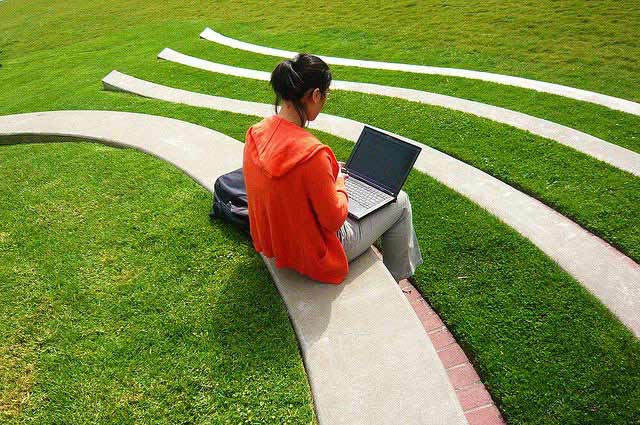 A girl studying outside on her laptop