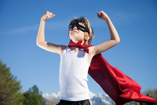 Young male confident in red cape superhero