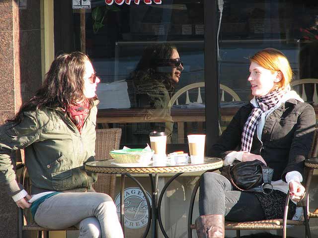 Two women having a conversation exchange over coffee