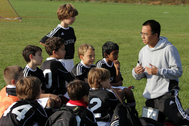 Man coaching young boys in Soccer