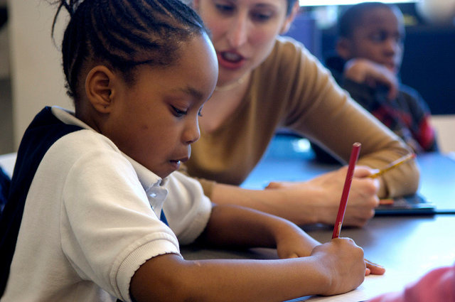 girl writing and being tutored 