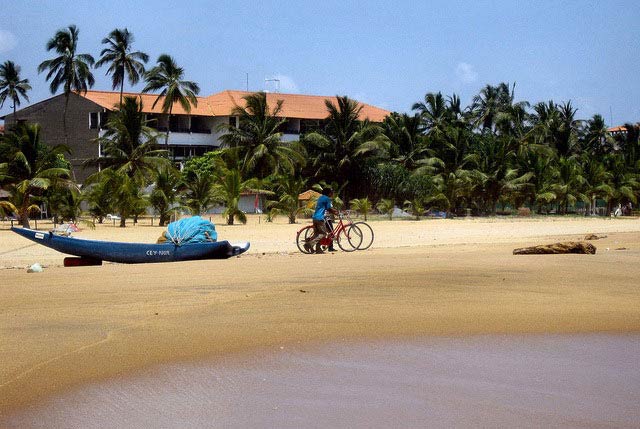 People riding bikes on the beach in Negombo, Sri Lanka