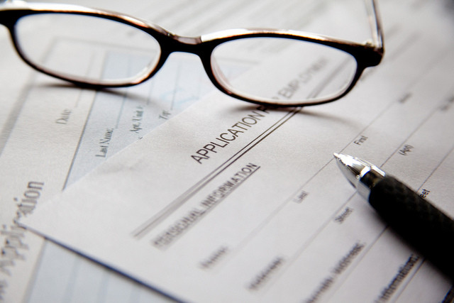 Glasses and pen on summer internship job application for college student