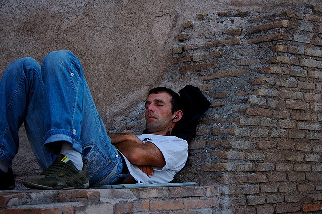 Man listening with earphones while sleeping