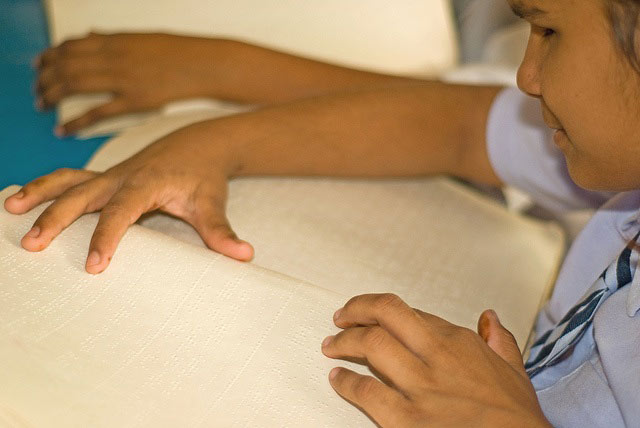 Student reading braille