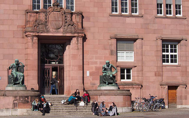 Students hanging out in front of a university campus.